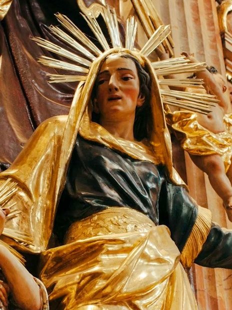 Statue of a woman and child with golden halos inside St Anne's Church.
