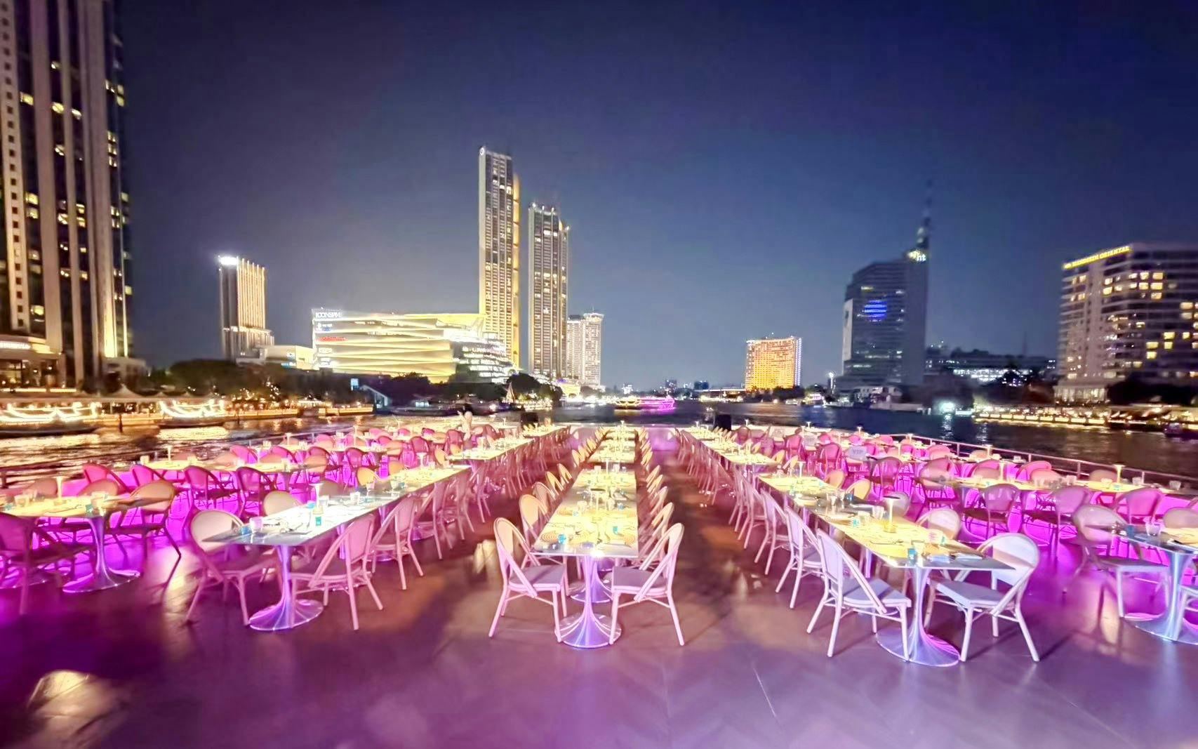 Upper deck dining with skyline views on Chao Phraya River dinner cruise in Bangkok.