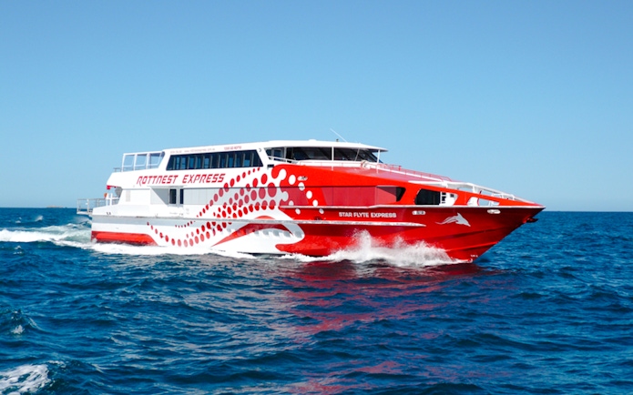 Red and white Rottnest Express ferry cruising through blue ocean waters.