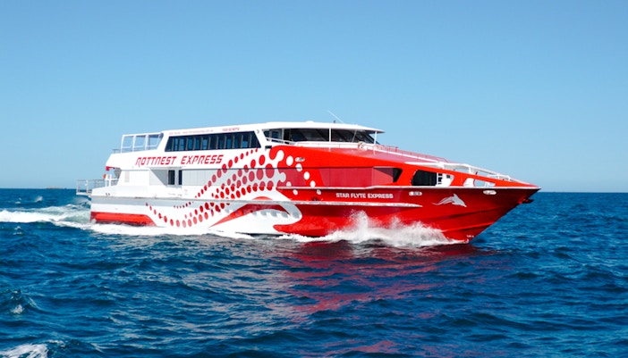 Red and white Rottnest Express ferry cruising through blue ocean waters.