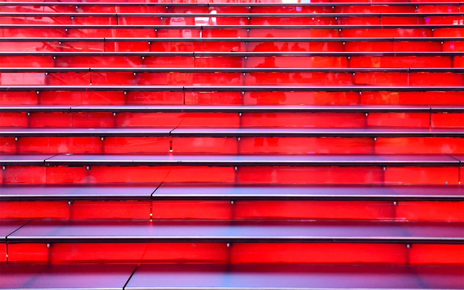Red stairs at Times Square, NYC, leading up in a symmetrical row.