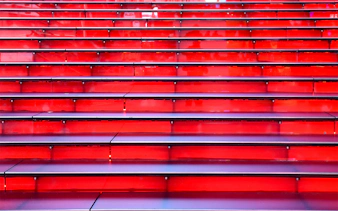 Red stairs at Times Square, NYC, leading up in a symmetrical row.