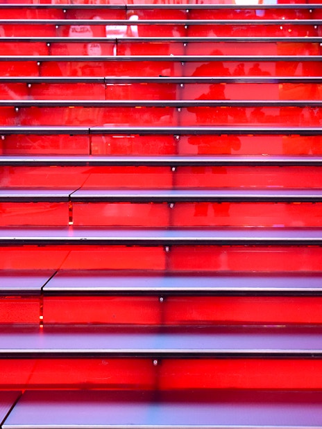 Red stairs at Times Square, NYC, leading up in a symmetrical row.