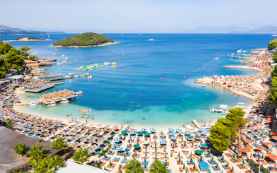 Ksamil Beach view with sun loungers, umbrellas, and clear blue water in Albania.