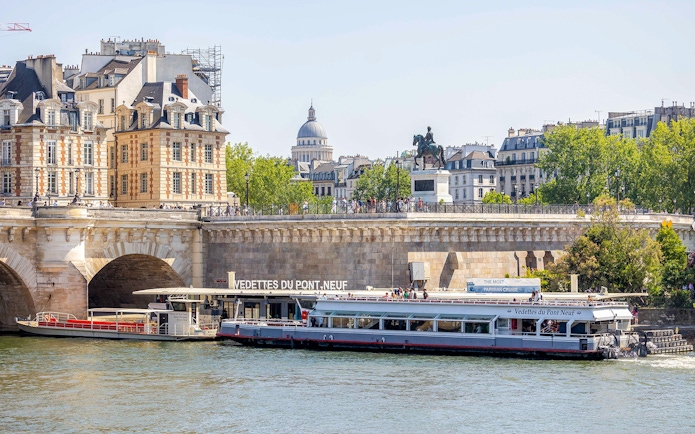 Seine river cruise boat docked at Pont Neuf in Paris.