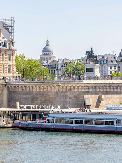 Seine river cruise boat docked at Pont Neuf in Paris.