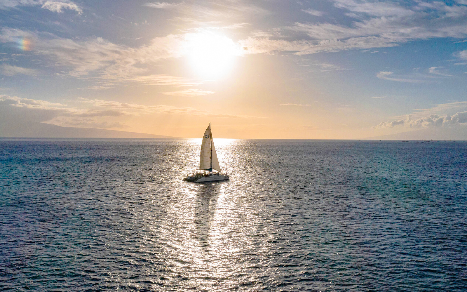 Sailboat on ocean during sunset in Maui, Hawaii, for whale watching and snorkeling tour.