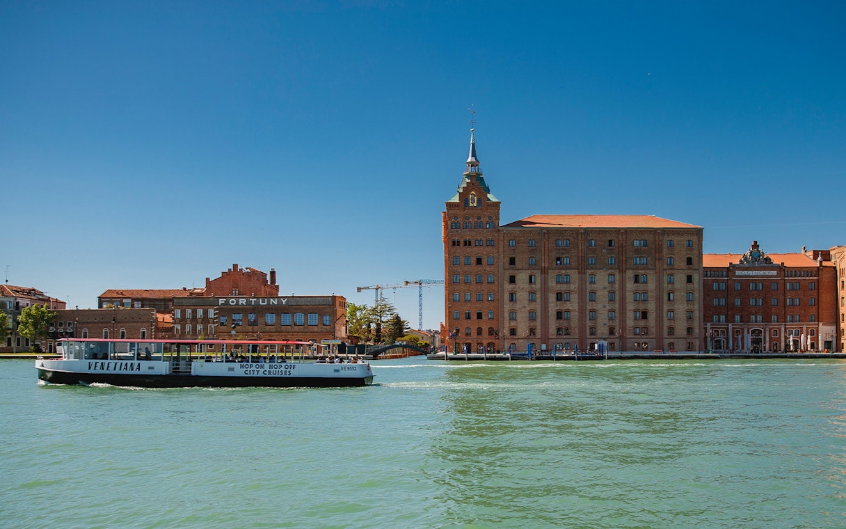 Venetian water bus cruising past historic buildings in Venice, Italy.