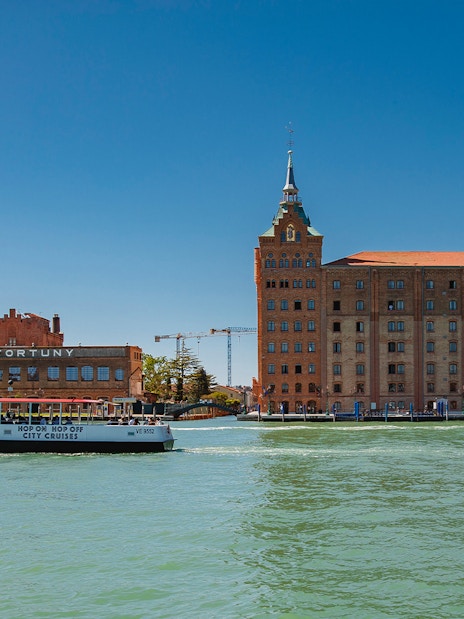 Venetian water bus cruising past historic buildings in Venice, Italy.