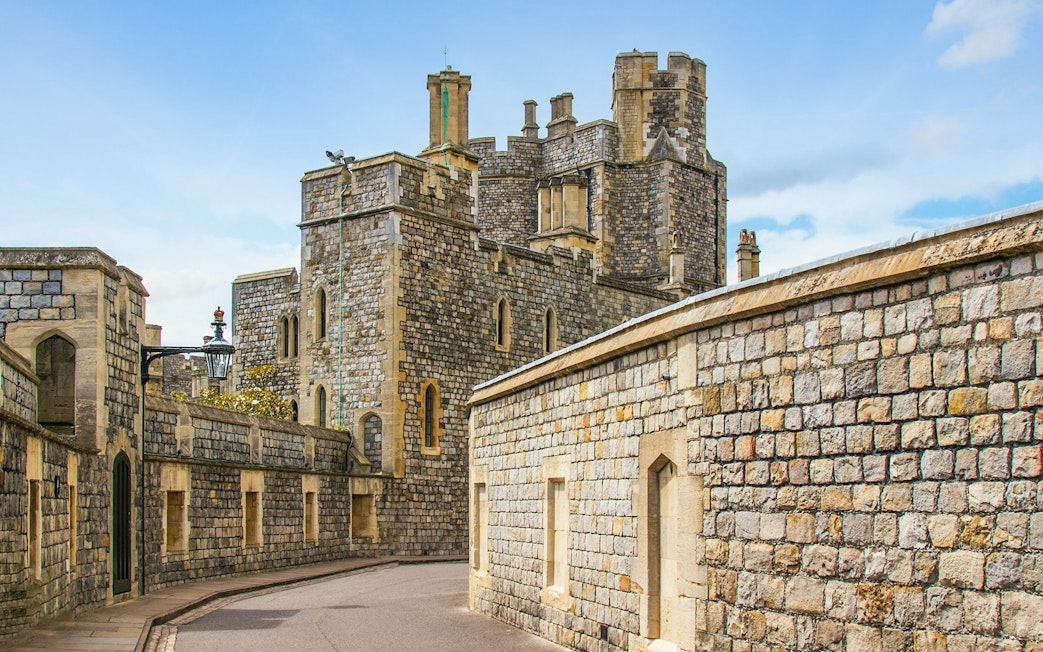 Windsor Castle stone walls and towers under a blue sky.