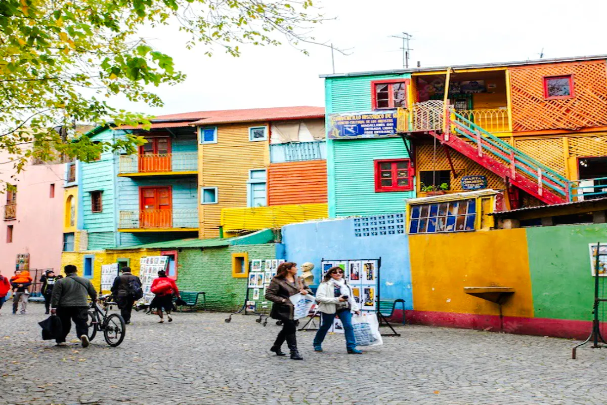 Colorful buildings and people walking in La Boca, Buenos Aires.