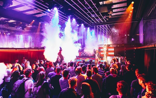 Crowd enjoying a live DJ performance with vibrant lights at Our House Museum of Electronic Dance Music.