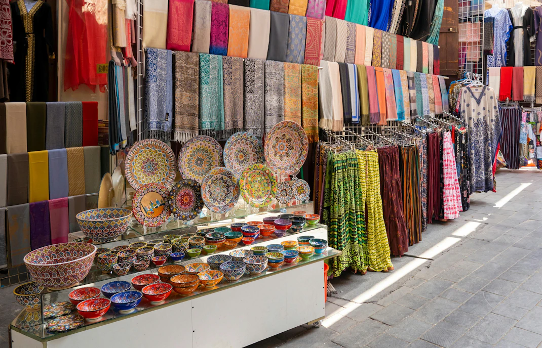 Colorful textiles and ceramics displayed at Dubai Textile Souk Market.
