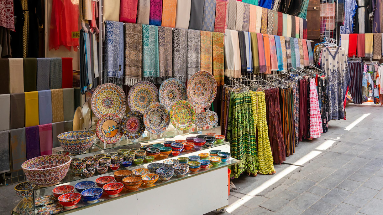 Colorful textiles and ceramics displayed at Dubai Textile Souk Market.