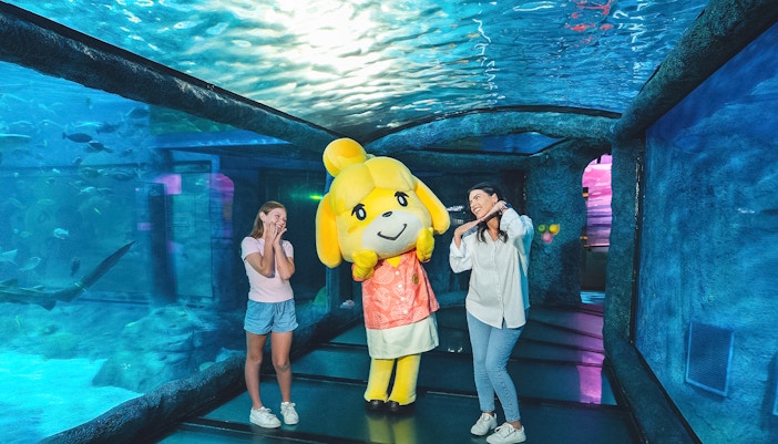 Mother and daughter with aquarium mascot at SEA LIFE Sydney Aquarium.