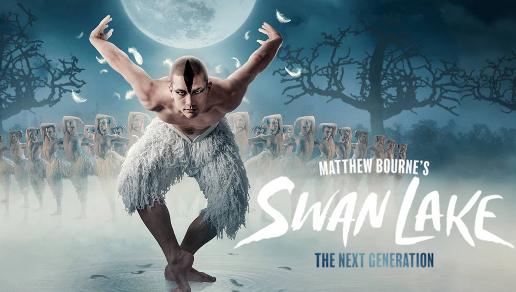Dancer in feathered costume performing in Matthew Bourne's Swan Lake under a full moon.