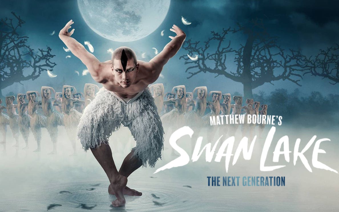 Dancer in feathered costume performing in Matthew Bourne's Swan Lake under a full moon.