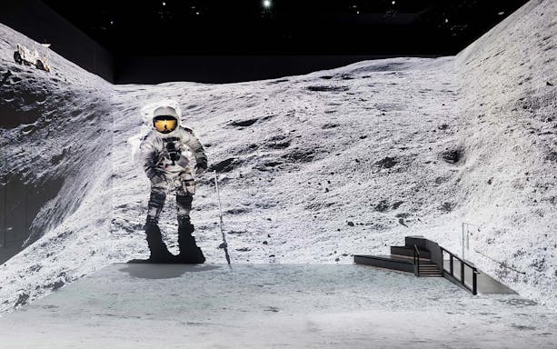 Astronaut walking on a simulated lunar surface for The Moonwalkers tour.