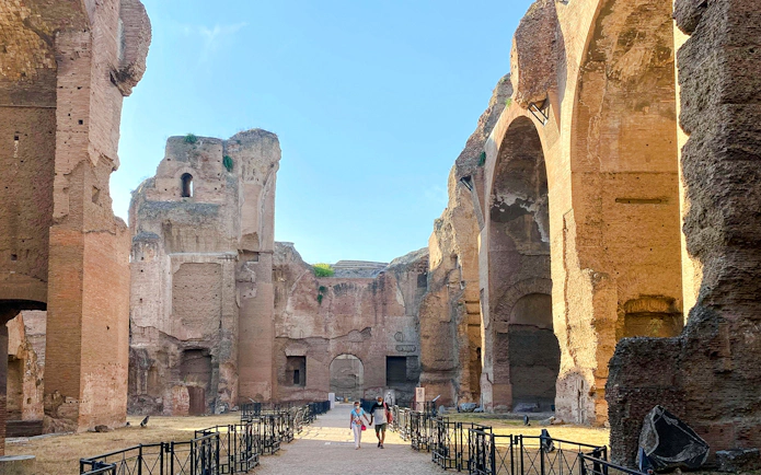 Ruins of the Baths of Caracalla in Rome, Italy, with ancient arches and pathways.
