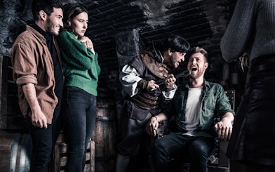 Visitors in a torture chamber scene at The Amsterdam Dungeon.