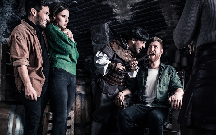 Visitors in a torture chamber scene at The Amsterdam Dungeon.