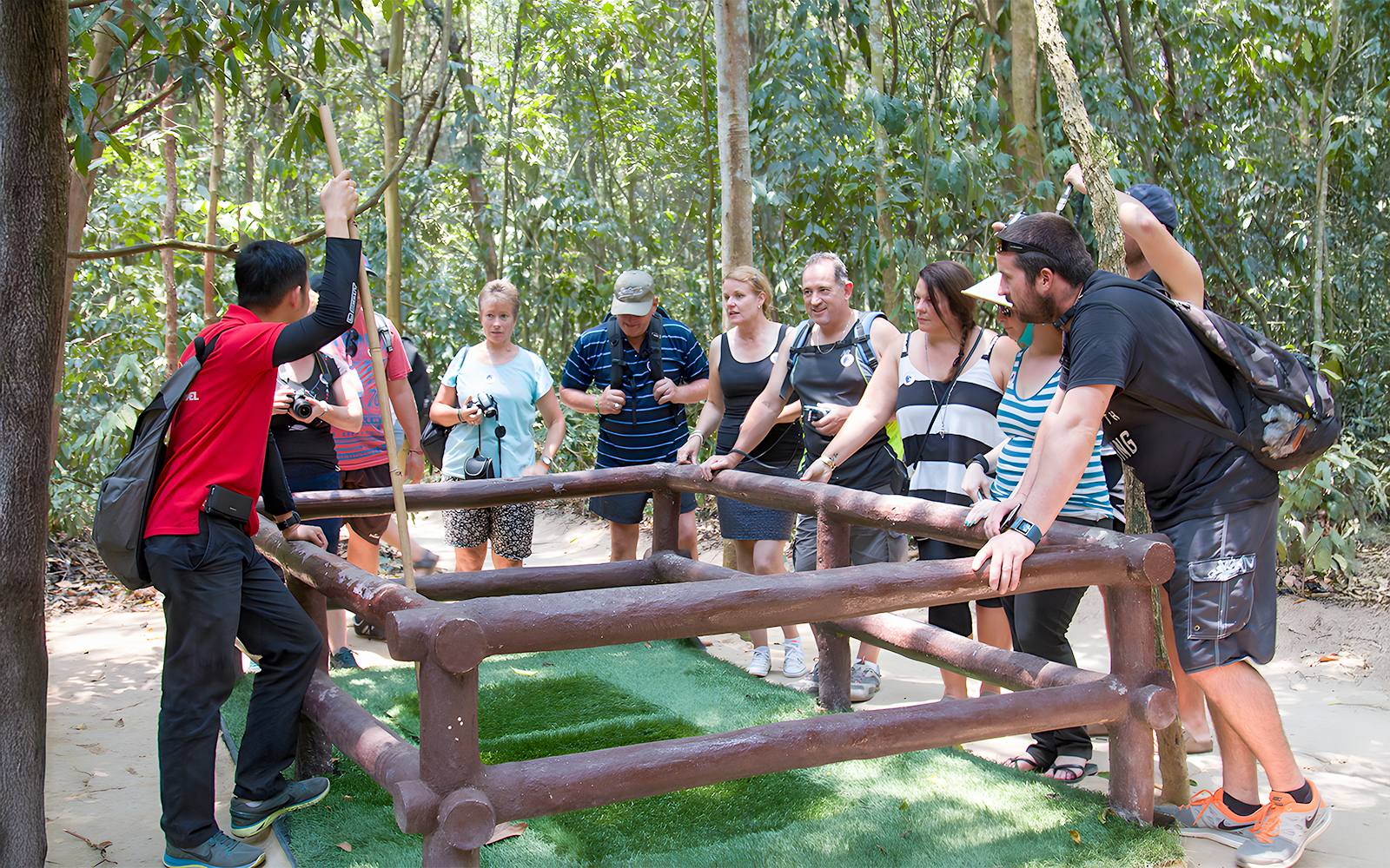 Guide demonstrating booby trap to tourists at Cu Chi Tunnel, Vietnam.