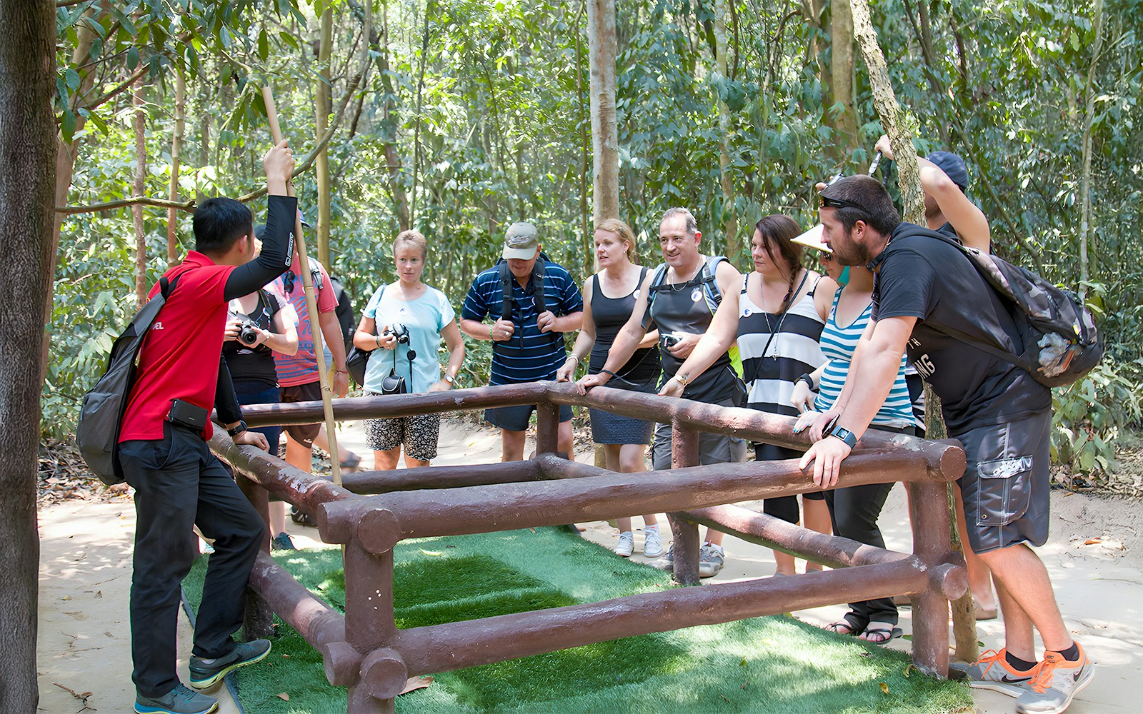 Guide demonstrating booby trap mechanism at Cu Chi Tunnels, Ho Chi Minh City, Vietnam.