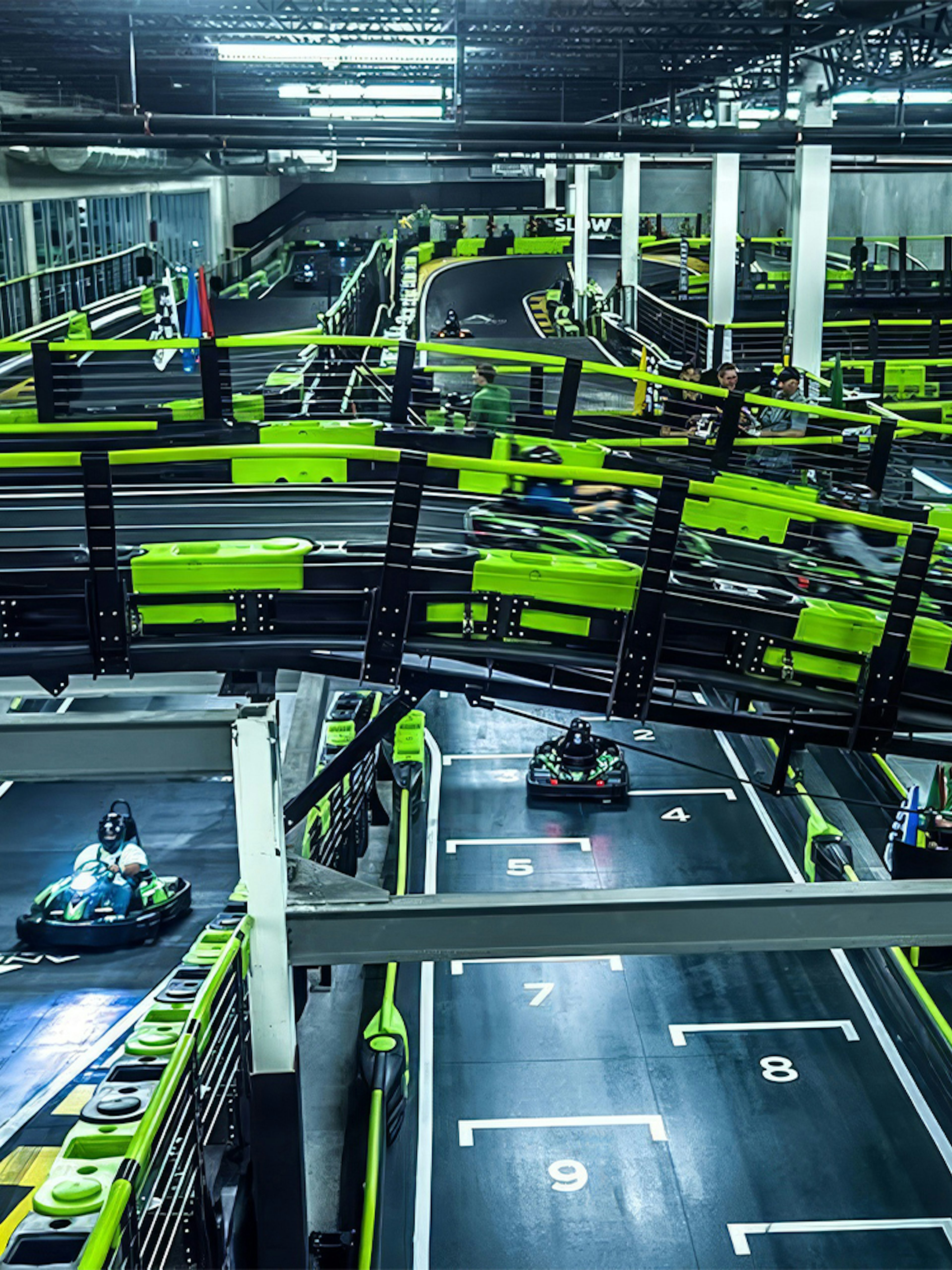Indoor go-kart track at Andretti Indoor Karting, Orlando, with racers navigating the course.