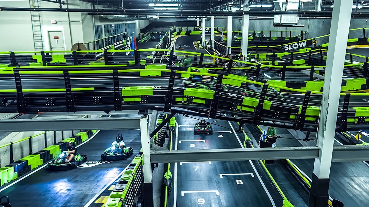 Indoor go-kart track at Andretti Indoor Karting, Orlando, with racers navigating the course.
