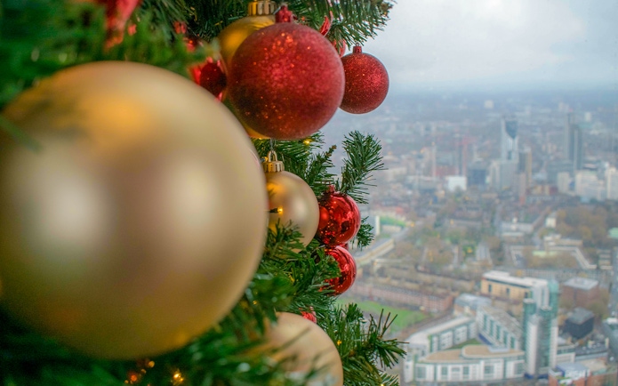 Christmas ornaments on a tree with a view of London from the Shard.