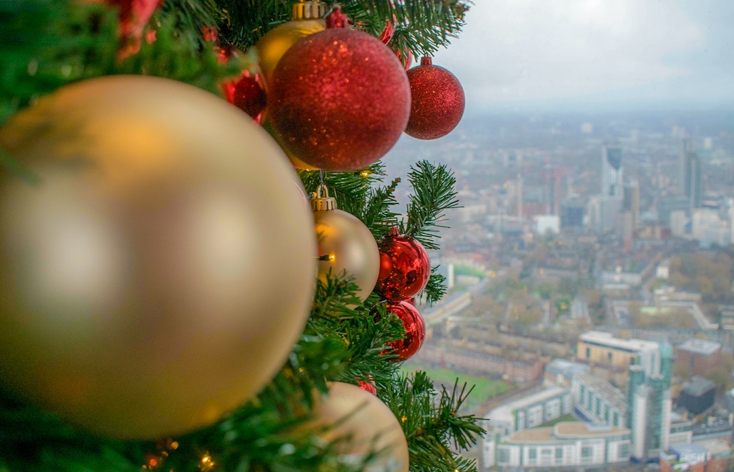 Christmas ornaments on a tree with a view of London from the Shard.