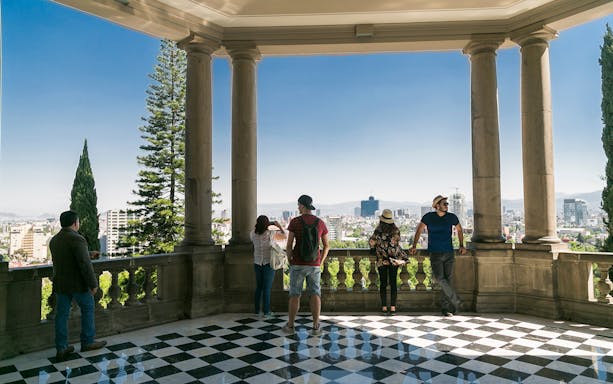 Visitors enjoying city views from Chapultepec Castle terrace during guided bike tour.