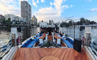 Nile Dahabiya dinner cruise with guests dining on a boat deck in Cairo.