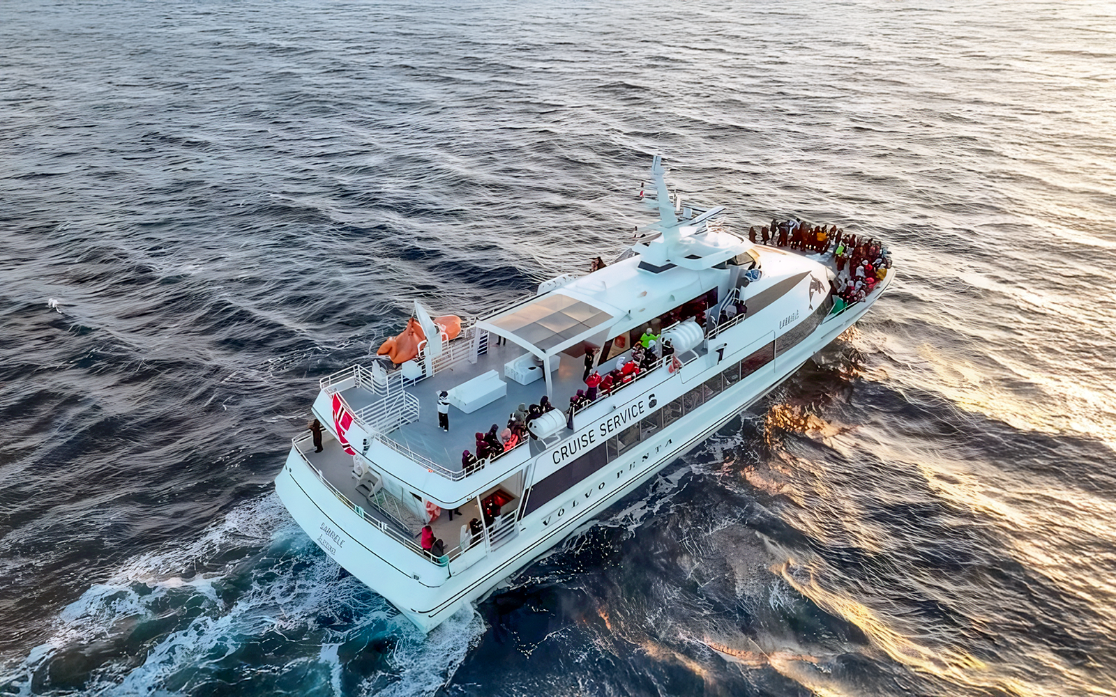 Motor catamaran on whale watching tour from Tromso, Norway, with passengers on deck.