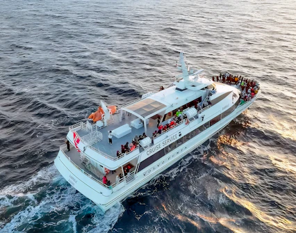 Motor catamaran on whale watching tour from Tromso, Norway, with passengers on deck.