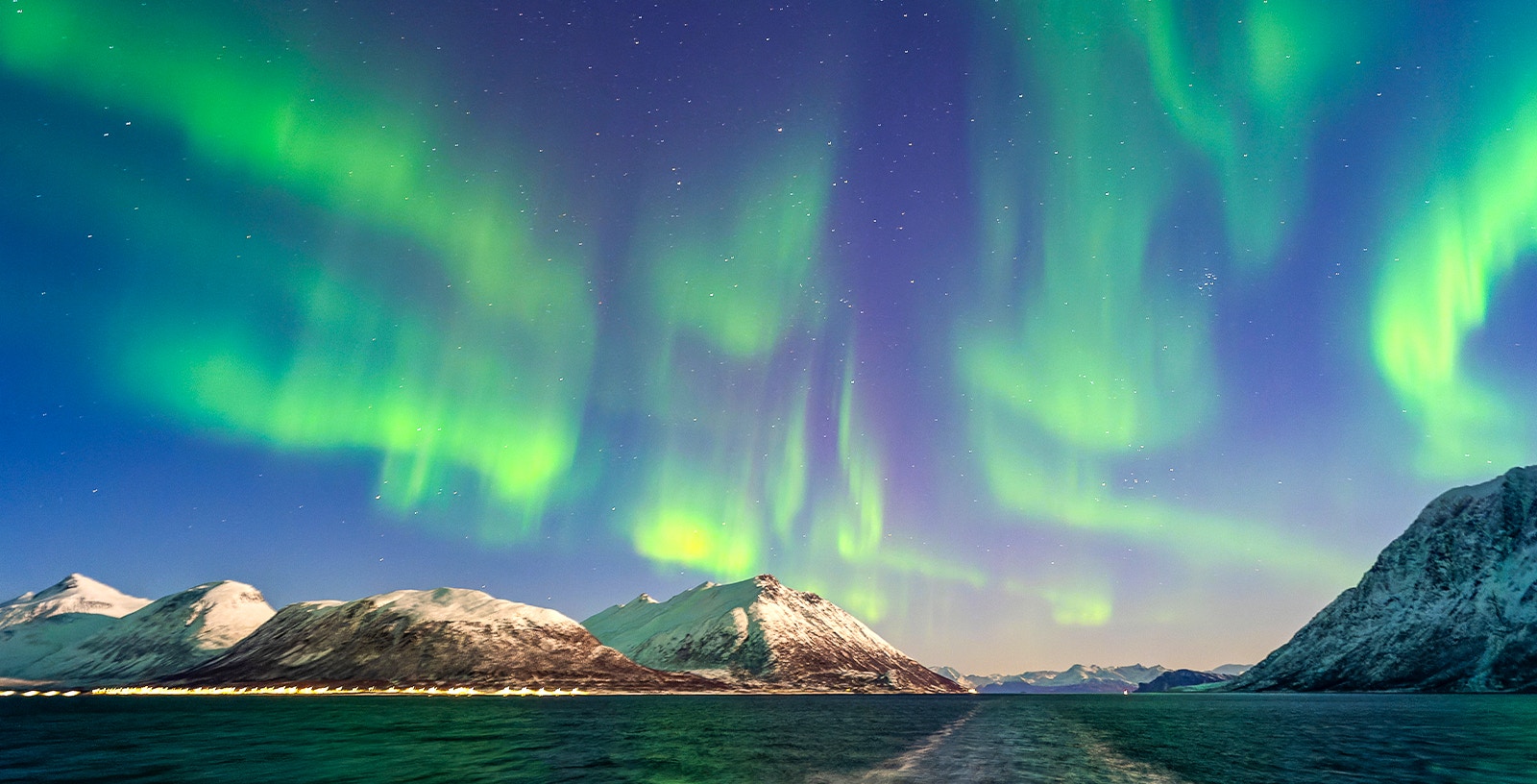 Northern Lights over Tromso fjord during a cruise in Norway.