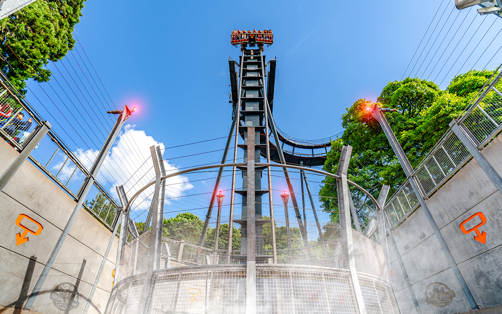 Oblivion ride drop tower at Alton Towers with blue sky and trees in background.