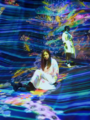 Visitors interacting with digital art installation at teamLab SuperNature.