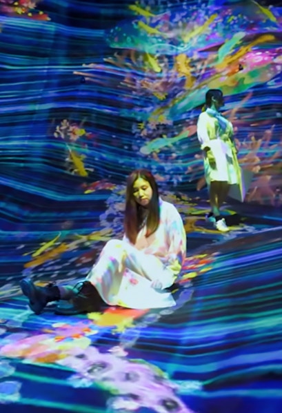 Visitors interacting with digital art installation at teamLab SuperNature.