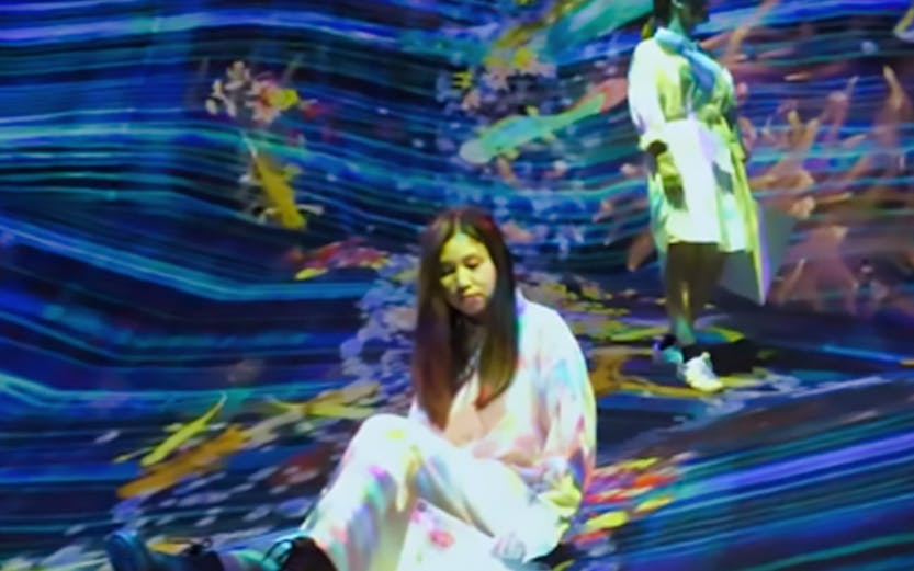 Visitors interacting with digital art installation at teamLab SuperNature.