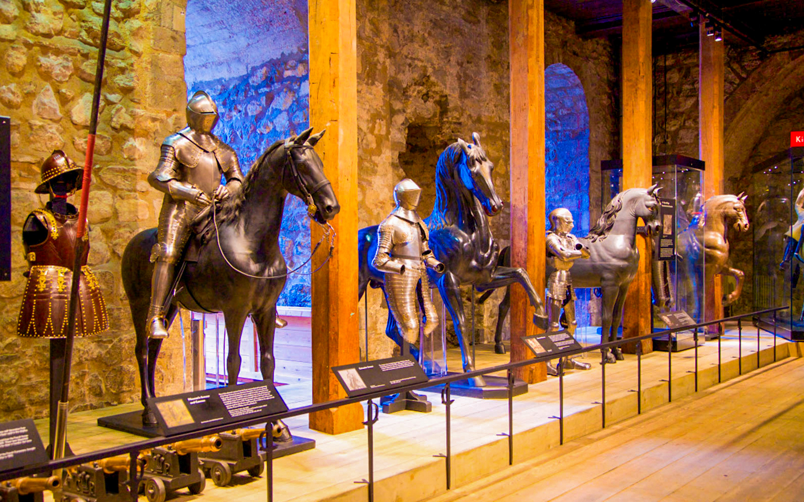 Medieval armor display at the Tower of London, featuring knights on horseback.