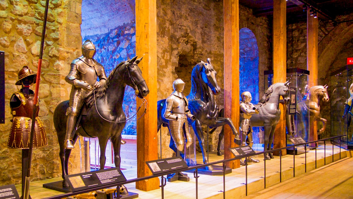 Medieval armor display at the Tower of London, featuring knights on horseback.