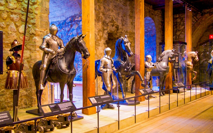 Medieval armor display at the Tower of London, featuring knights on horseback.