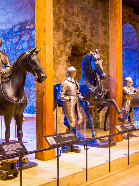 Medieval armor display at the Tower of London, featuring knights on horseback.