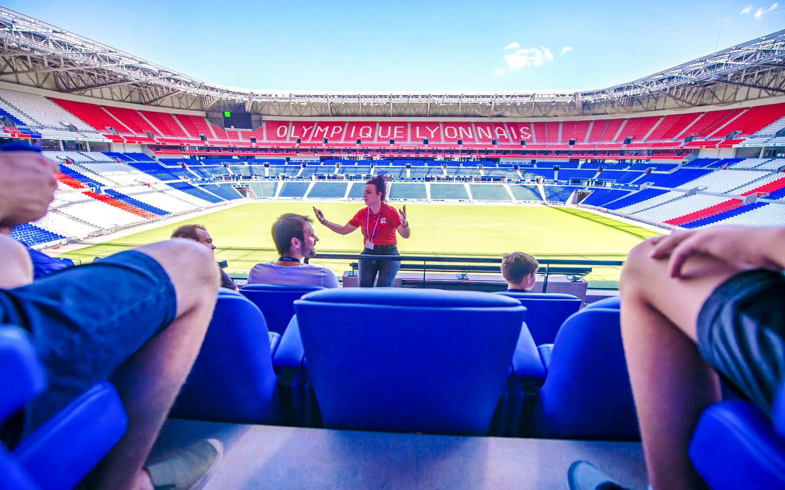 Tour guide speaking to visitors at Olympique Lyonnais stadium museum, Lyon, France.