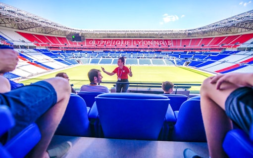 Tour guide speaking to visitors at Olympique Lyonnais stadium museum, Lyon, France.