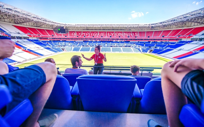 Tour guide speaking to visitors at Olympique Lyonnais stadium museum, Lyon, France.