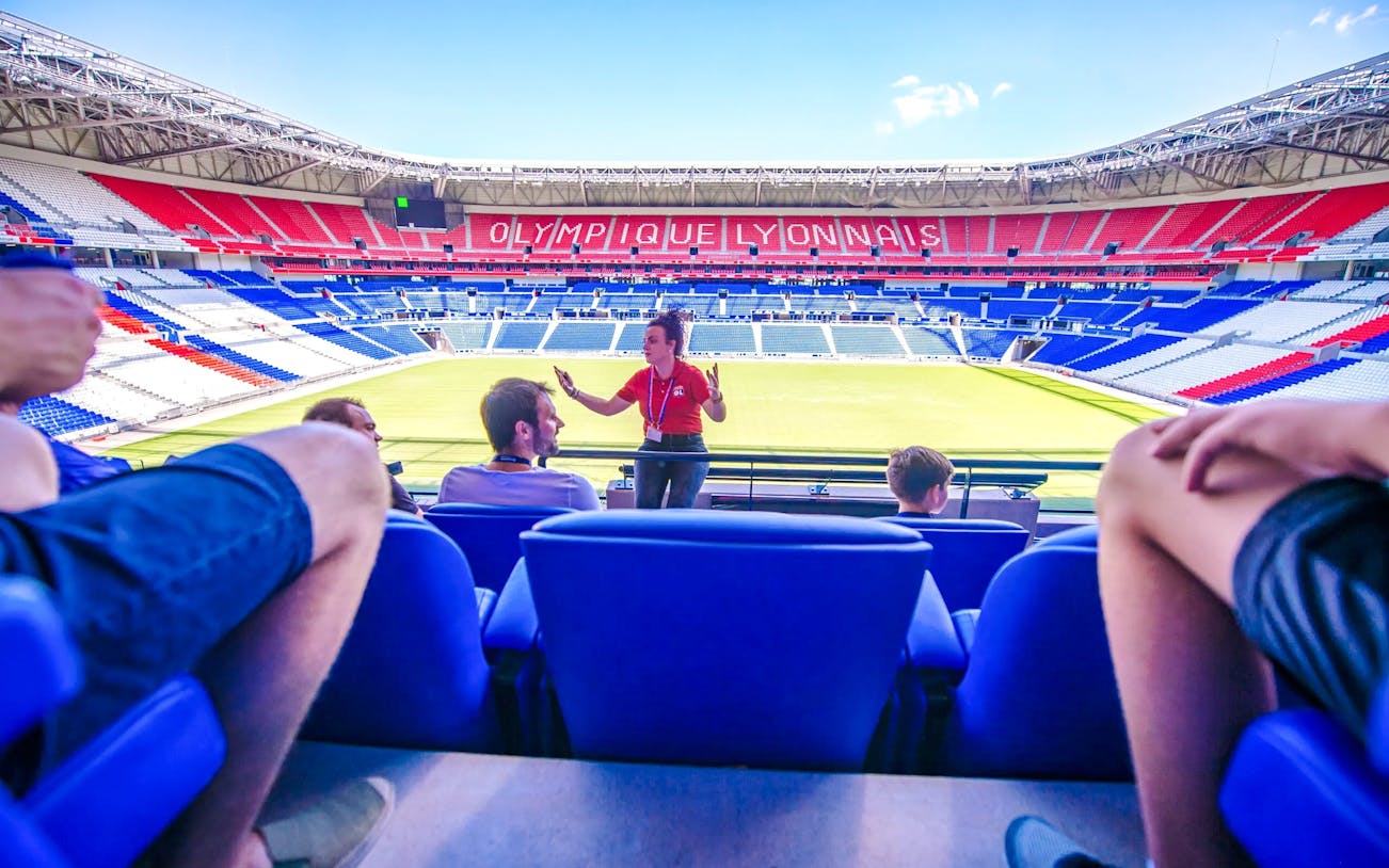 Tour guide speaking to visitors at Olympique Lyonnais stadium museum, Lyon, France.
