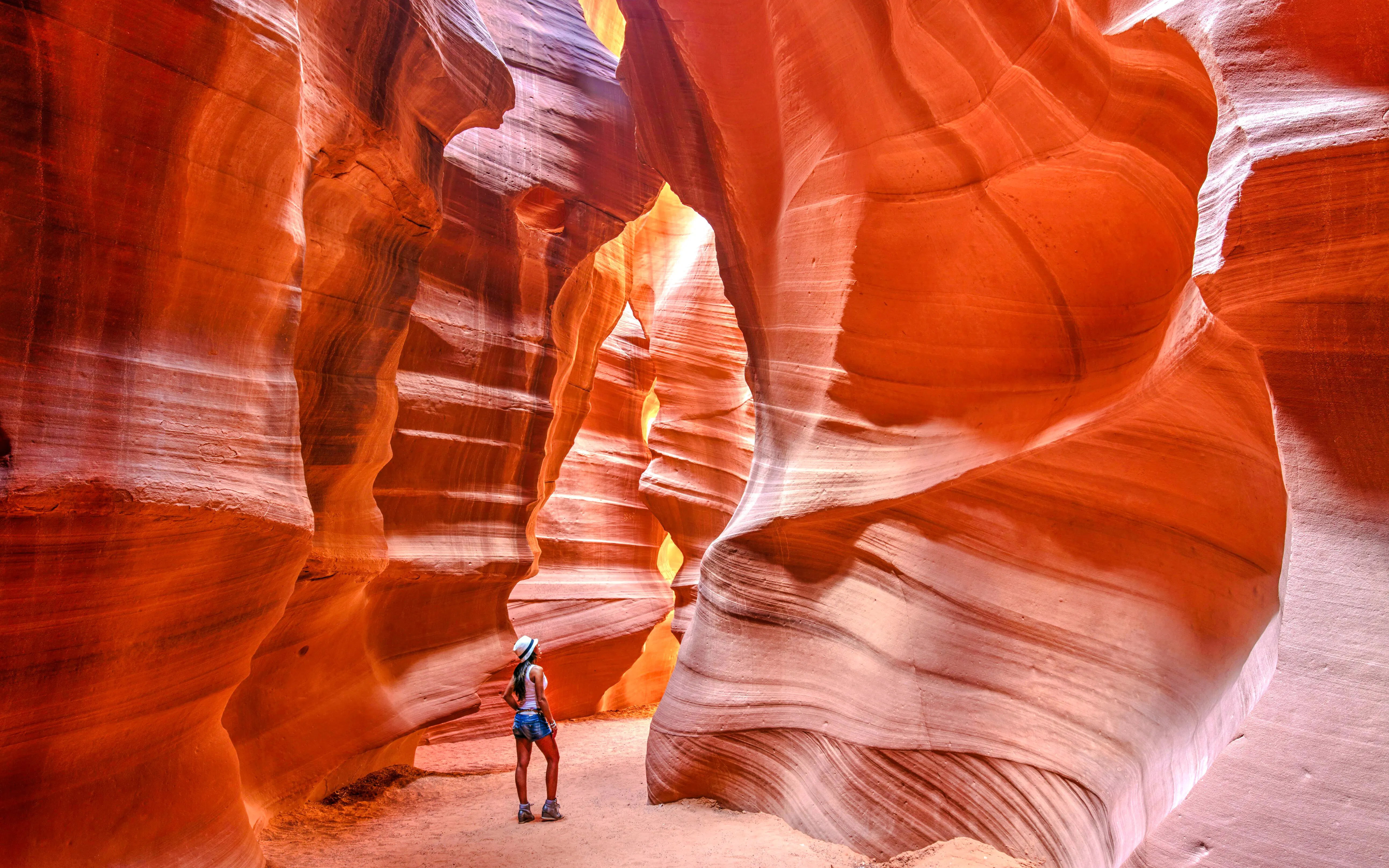 Visitor exploring the narrow sandstone walls of Antelope Canyon on a small group tour.