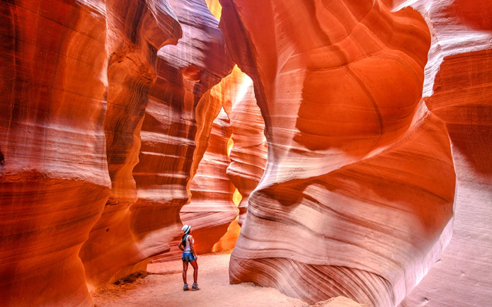 Visitor exploring the narrow sandstone walls of Antelope Canyon on a small group tour.